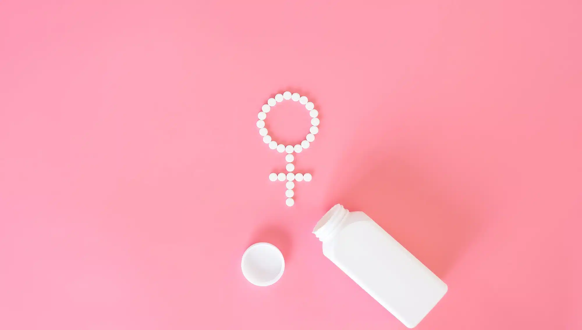 Pills on a pink background, flat lay, women's health.
